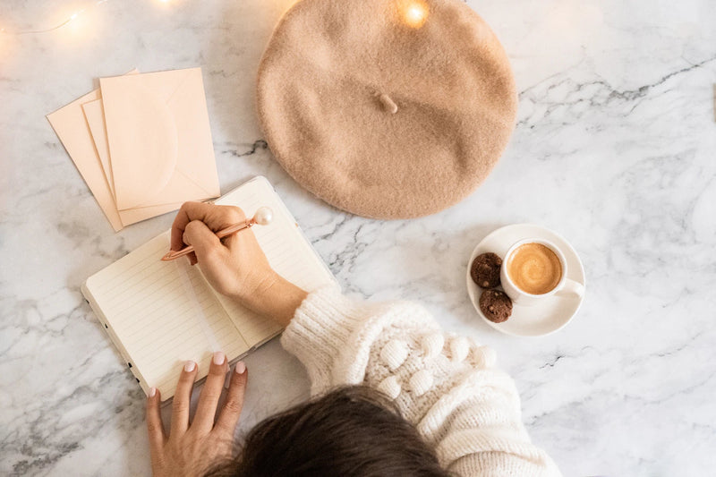 A traveller writing down questions at a quiet hotel desk.