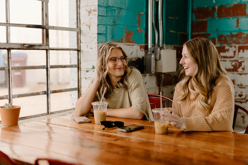 Two friends deciding between two desserts at a contemporary café.
